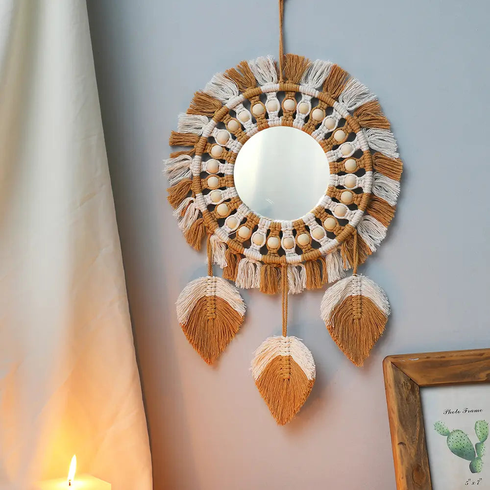 Boho macrame wall mirror with a beige and cream woven frame, wooden beads, and leaf-shaped tassels for living room home decor.