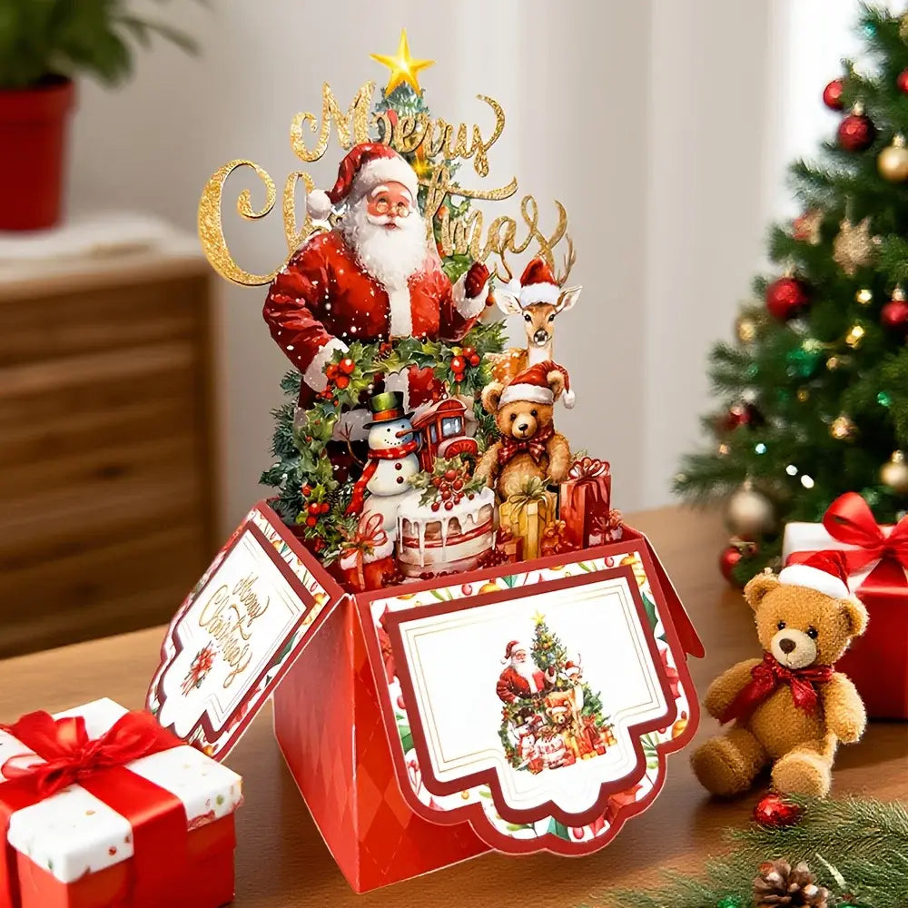 赤の3Dサンタクロースのクリスマス飛び出す（ポップアップ）グリーティングカードで、サンタクロースの像がトナカイ、雪だるま、テディベアに囲まれた華やかなセンターピースを特徴としています。