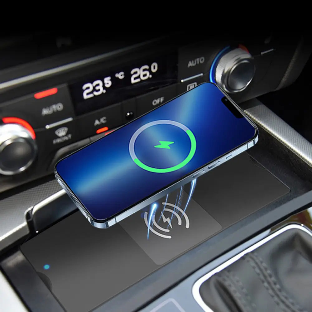 A sleek silver-framed smartphone with a blue screen displaying a green charging icon rests on a silver Audi A6 A7 wireless car charger 15w fast pad.