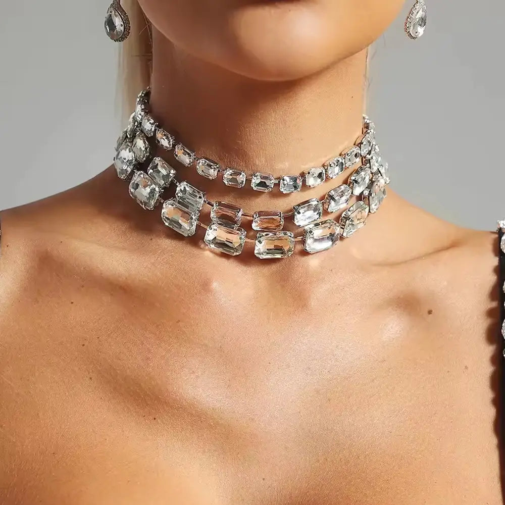 A sparkling multi-strand crystal statement choker necklace for women featuring clear rectangular-cut crystals set in a sleek silver-toned metal frame.