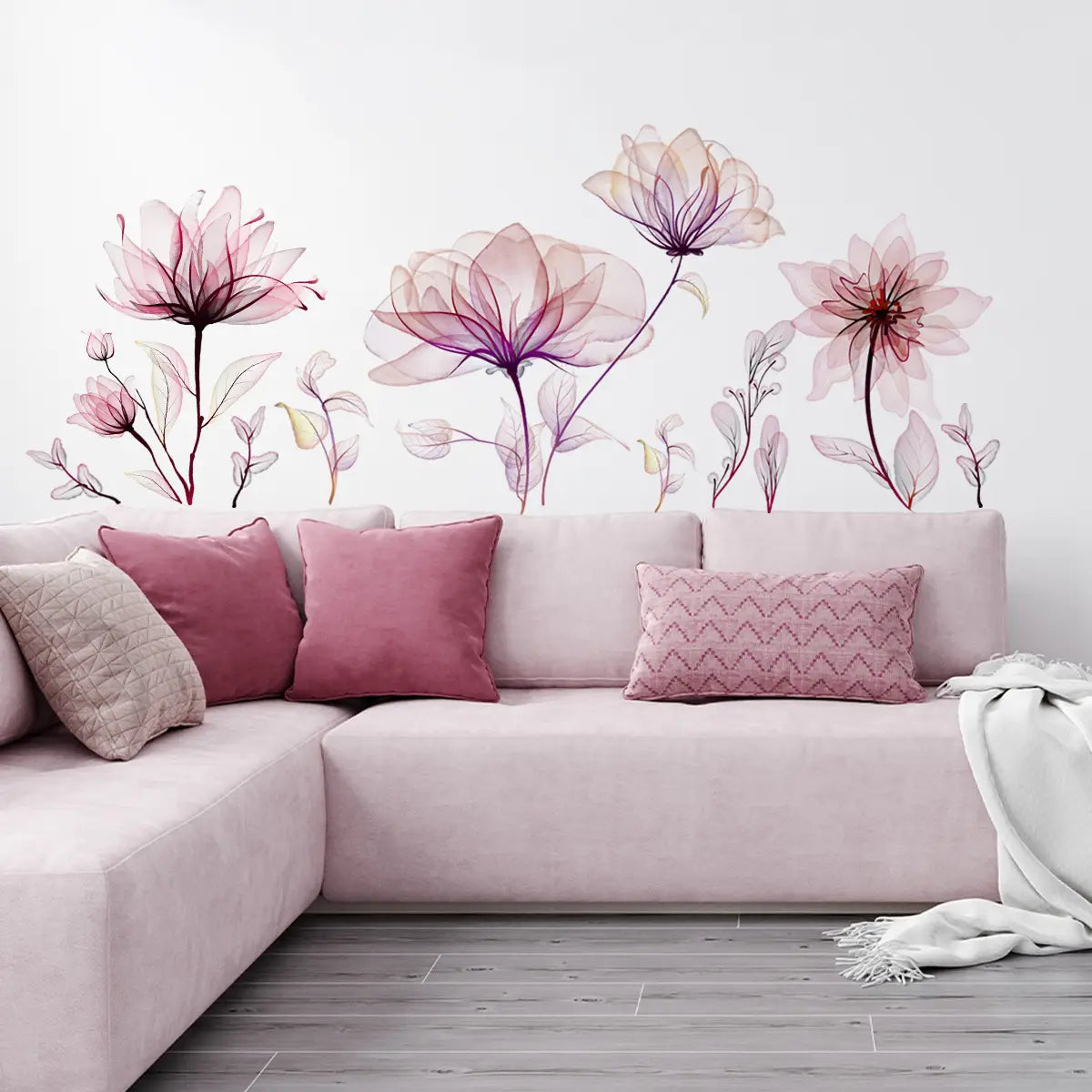 Pastel pink sectional sofa with plush velvet upholstery and decorative pillows in mauve rose and beige shown with pink floral wall stickers peel and stick decals.