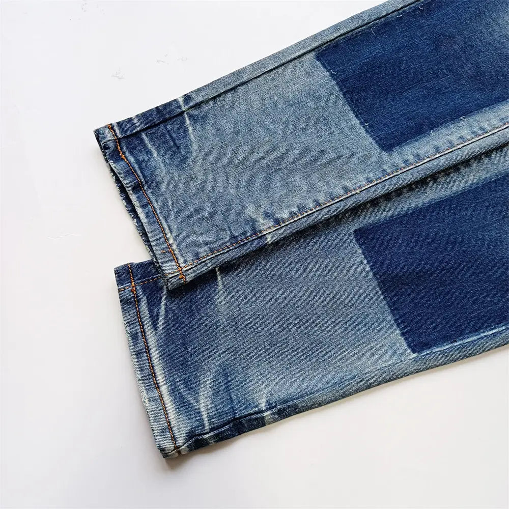 Jeans skinny déchirés pour hommes, effet délavé rétro vintage bleu, présentant un denim bleu avec un design de type patchwork composé d’empiècements en denim bleu plus foncé.