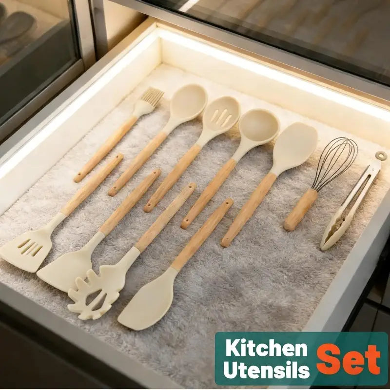 Set of 14 piece silicone kitchen utensils with wooden handles and off-white silicone heads including spatulas spoons a whisk and tongs.