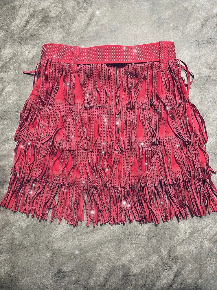 Mini-jupe taille haute rouge vif en suède à franges en strass, avec franges superposées et ornements en strass scintillants le long de la ceinture.