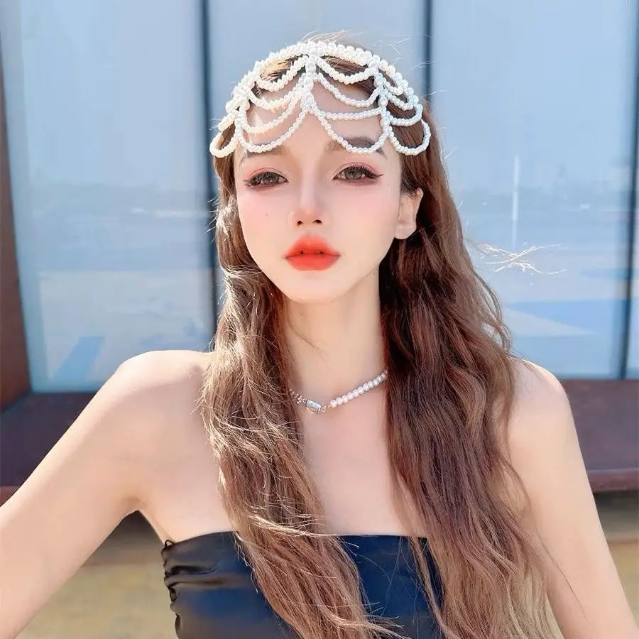 A delicate white pearl bridal crown hair band with an intricate cascading tassel design.