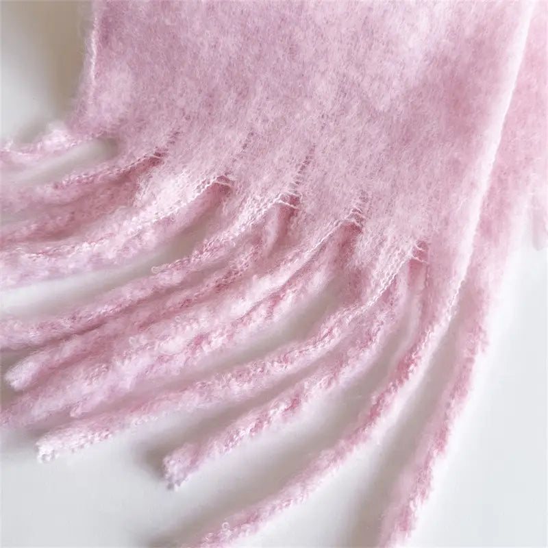 Ein weicher Pastellrosa-Schal für Damen mit Cashmere-ähnlichem Gefühl für den Winter mit flauschig wirkender Textur und filigranen Fransen-Details.