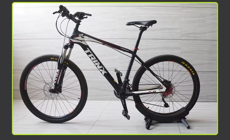 Support de stationnement pour vélo réglable et rack de rangement accueillant un vélo tout-terrain Trinx noir et blanc, avec des accents rouges sur les jantes et des freins à disque.