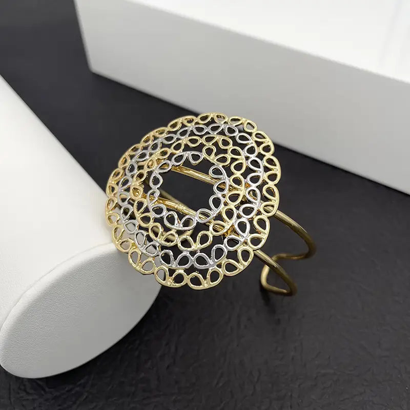 Bracelet jonc manchette en filigrane bicolore or et argent, avec un motif circulaire ajouré complexe, pour un ensemble de bijoux pour femmes.