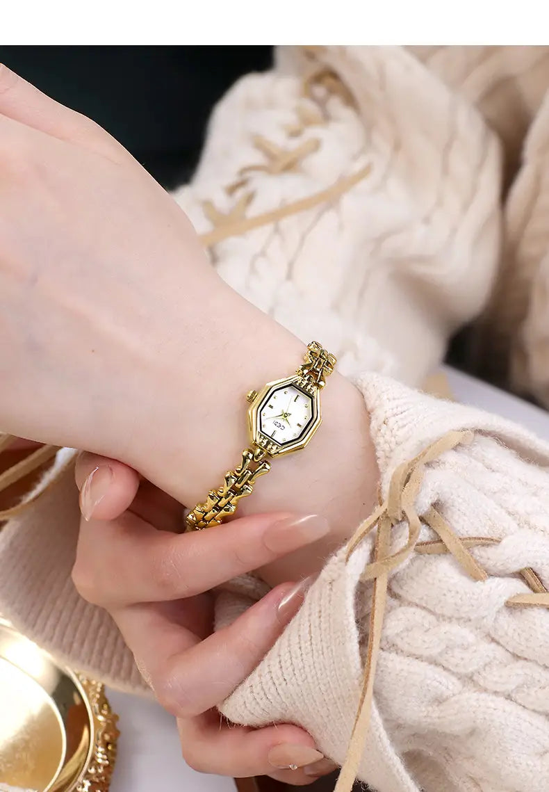Gold-toned octagonal ladies luxury quartz wristwatch with a delicate chain-link bracelet and white dial.