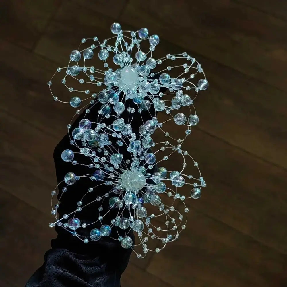 Boucles d’oreilles pendantes en forme de goutte de fleur en cristal comprenant de délicates perles bleu transparent et claires, avec un travail de fil complexe, pour un mariage.
