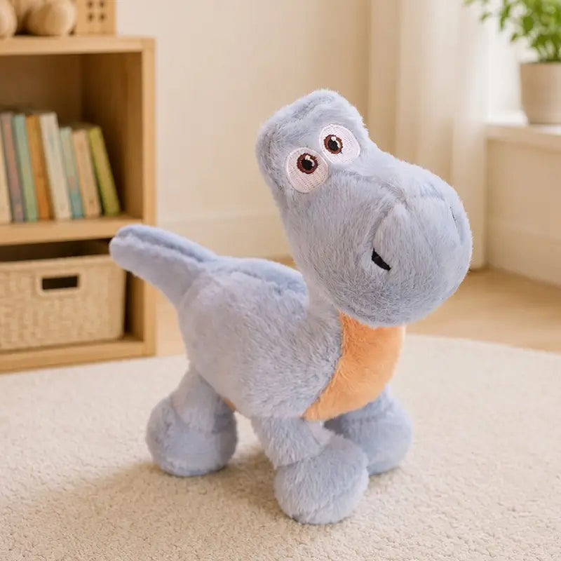 Un jouet peluche de dinosaure coloré doux bleu clair, avec un écusson de ventre orange et un visage amical composé d’un matériau de peluche souple.