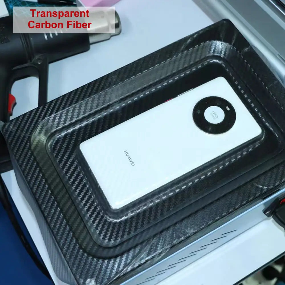 Teléfono móvil Huawei blanco, acomodado en una funda protectora transparente de fibra de carbono, mostrado con una máquina de laminación al vacío de película para teléfonos móviles para optimizar el costo de envío y la protección del dispositivo.