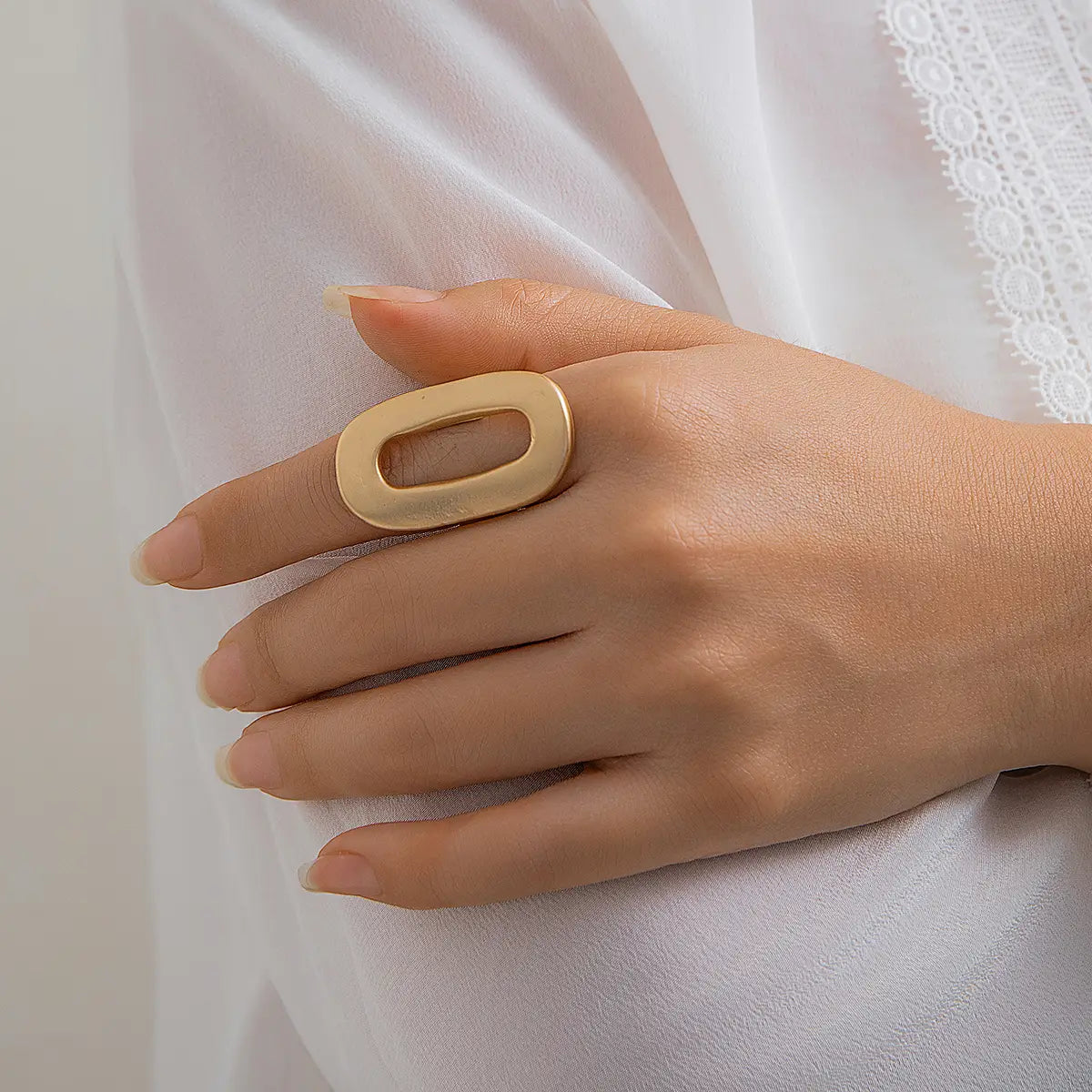 Gold-toned minimalist geometric oval open ring for women with a sleek oval shape and a centered rectangular cutout.