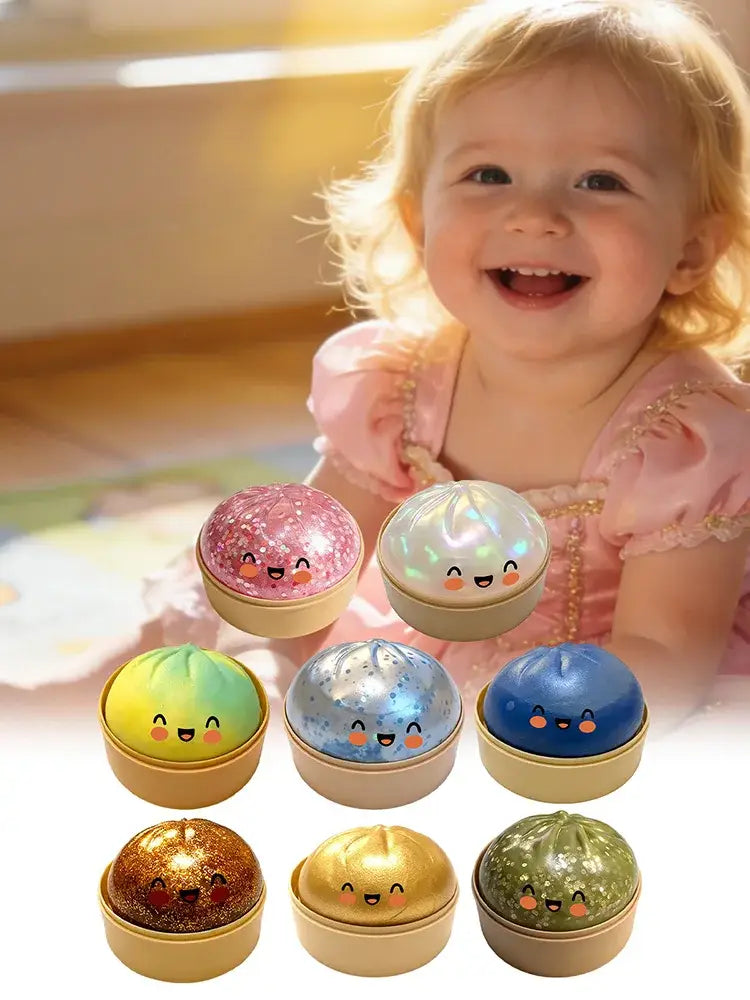 juguetes exprimibles de panecillo al vapor con forma de dumpling, con purpurina y de colores pastel y metálicos, con caritas sonrientes, exhibidos dentro de un recipiente para vapor