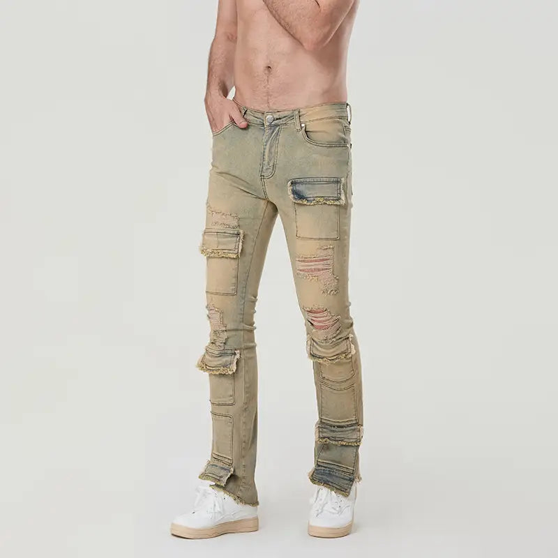 Des jeans empilés déchirés pour hommes, coupe slim, style streetwear, en denim olive délavé, avec plusieurs sections déchirées et reconstituées.