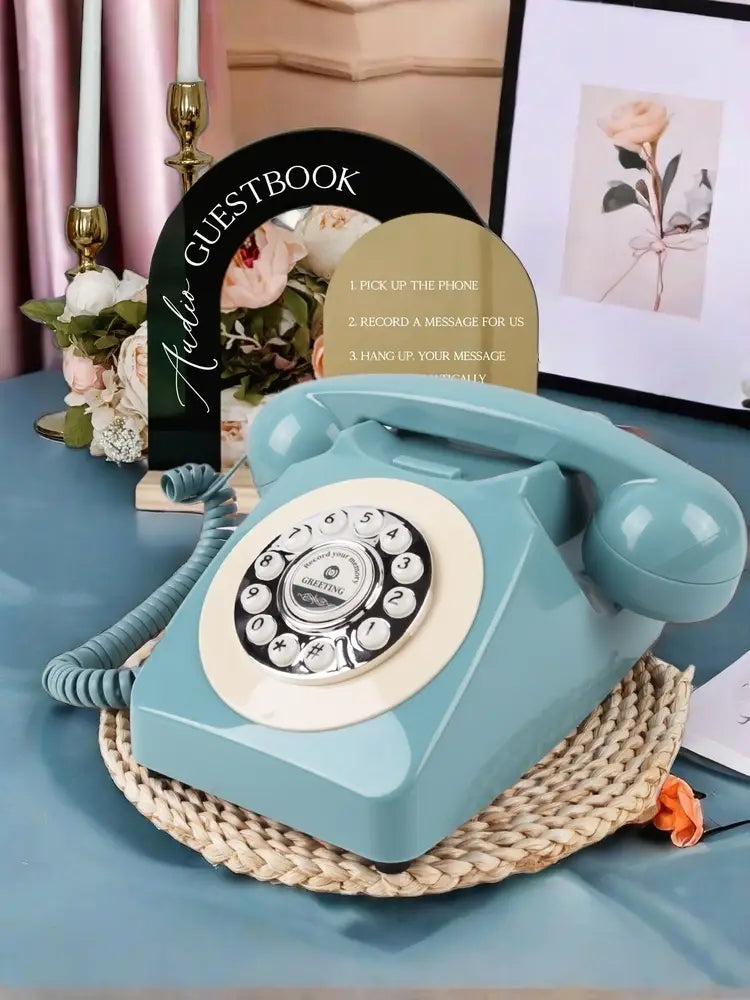 Teléfono de registro de audio antiguo para bodas y eventos con un teléfono rotatorio turquesa con un dial circular color crema y marcas de números negras, apoyado sobre una alfombrilla tejida.