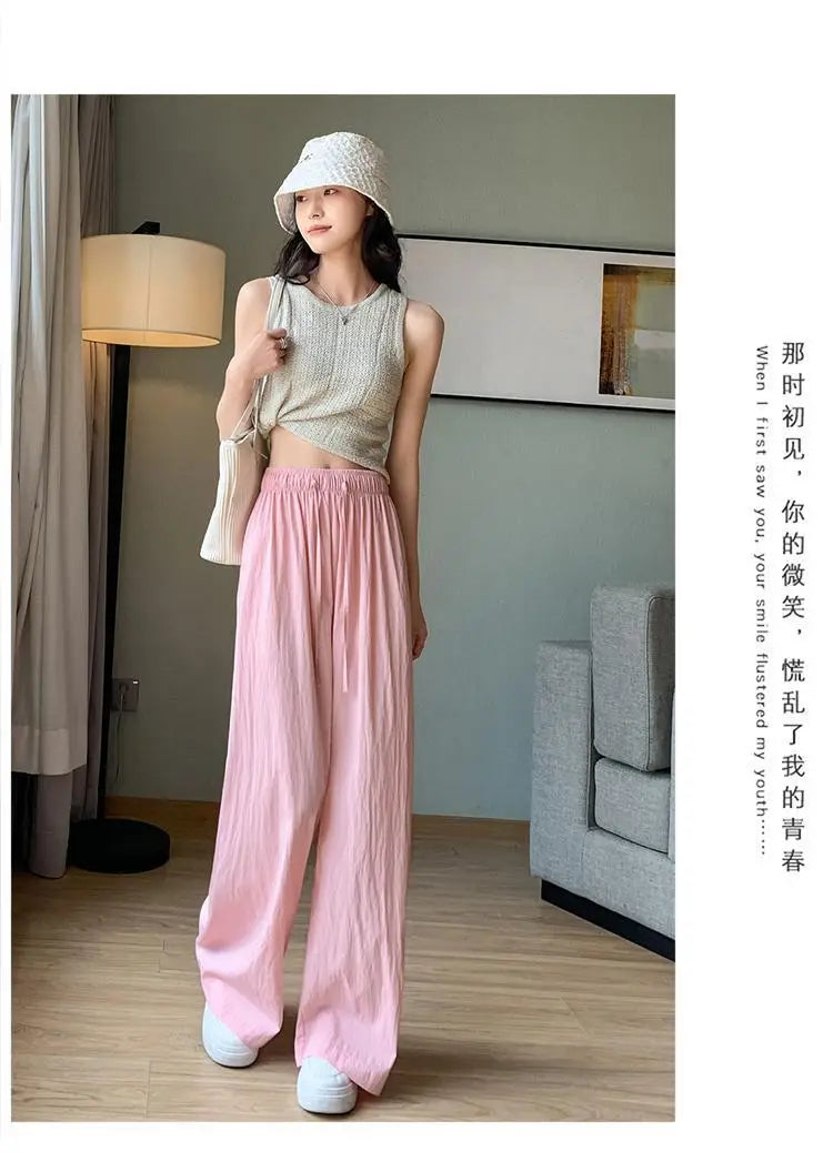 Rosa weite Plissee-Hose für Damen mit entspannter, fließender Silhouette und dezenten vertikalen Falten, ideal für die Sommerzeit.