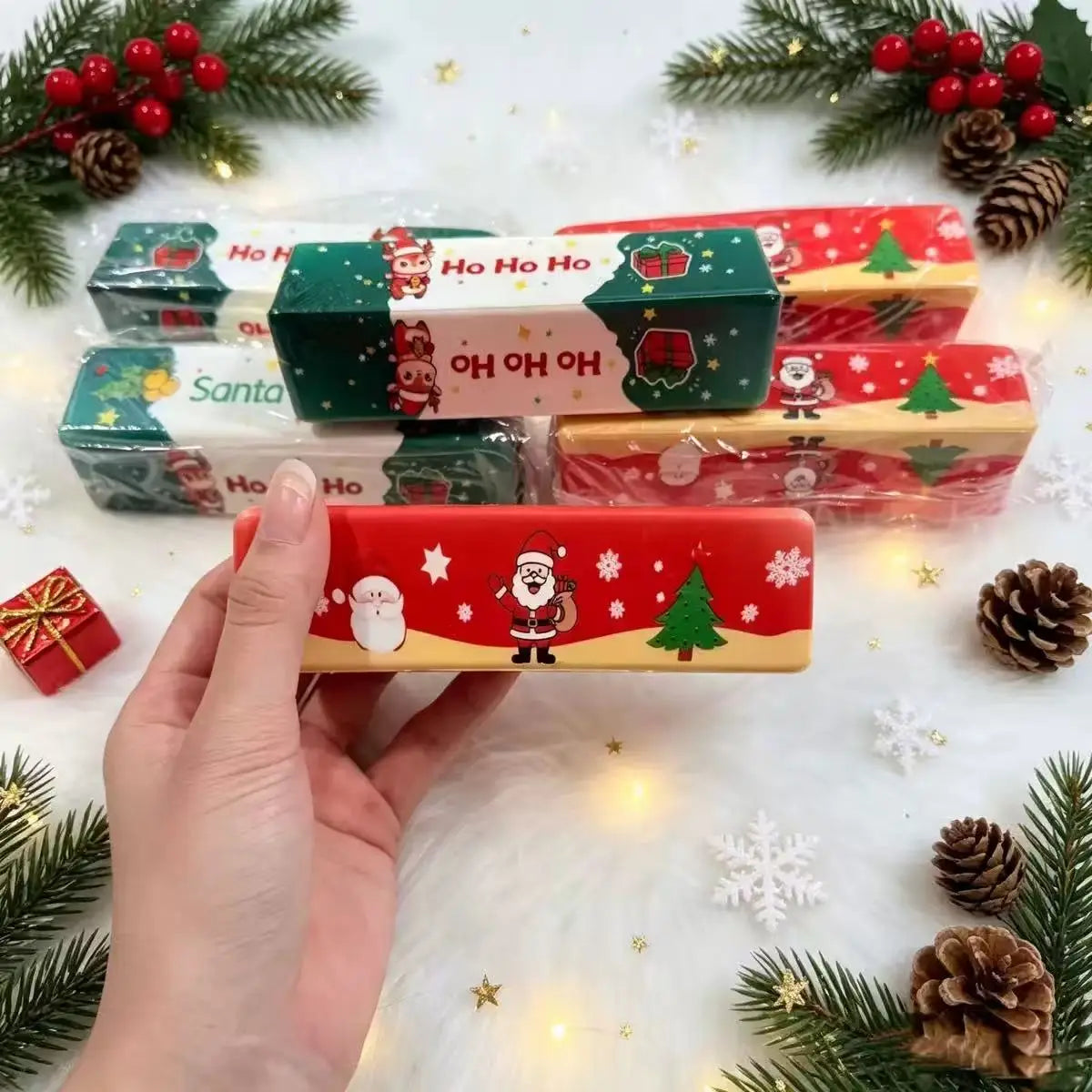 Estuche para lápices de mantequilla blanda y esponjosa con temática navideña en rojo y dorado, con ilustraciones de Santa, muñeco de nieve y árbol, diseñado como un juguete blando de descompresión lenta para aliviar el estrés.