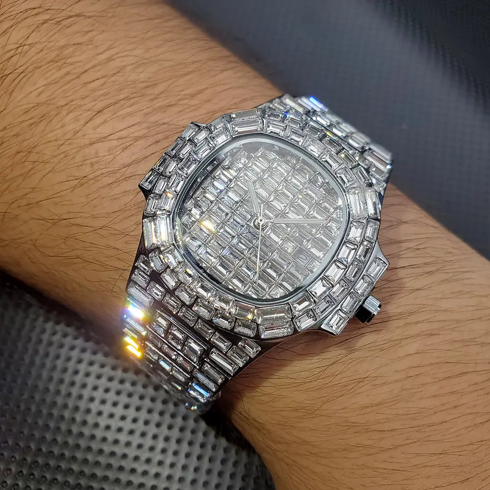 Iced out diamond quartz watch for men with a dazzling diamond-encrusted silver stainless steel case and bracelet featuring an octagonal face adorned with numerous baguette-cut stones.