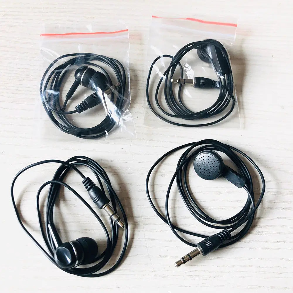 Écouteurs filaires noirs avec prises audio 3,5 mm, design intra-auriculaire compact et câbles spiralés pour les appareils mp3 mp4, stockage ou présentation.