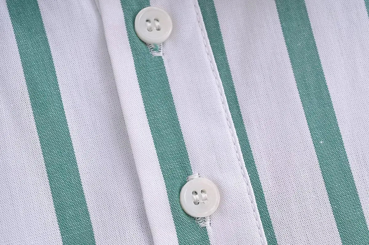 white buttons with four holes on a green striped short sleeve crop shirt featuring alternating white and teal vertical stripes fabric