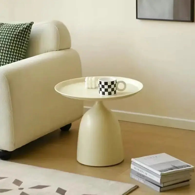 Cream-colored ceramic coffee table side table with a sleek bell-shaped base and flat circular top for modern living room use.