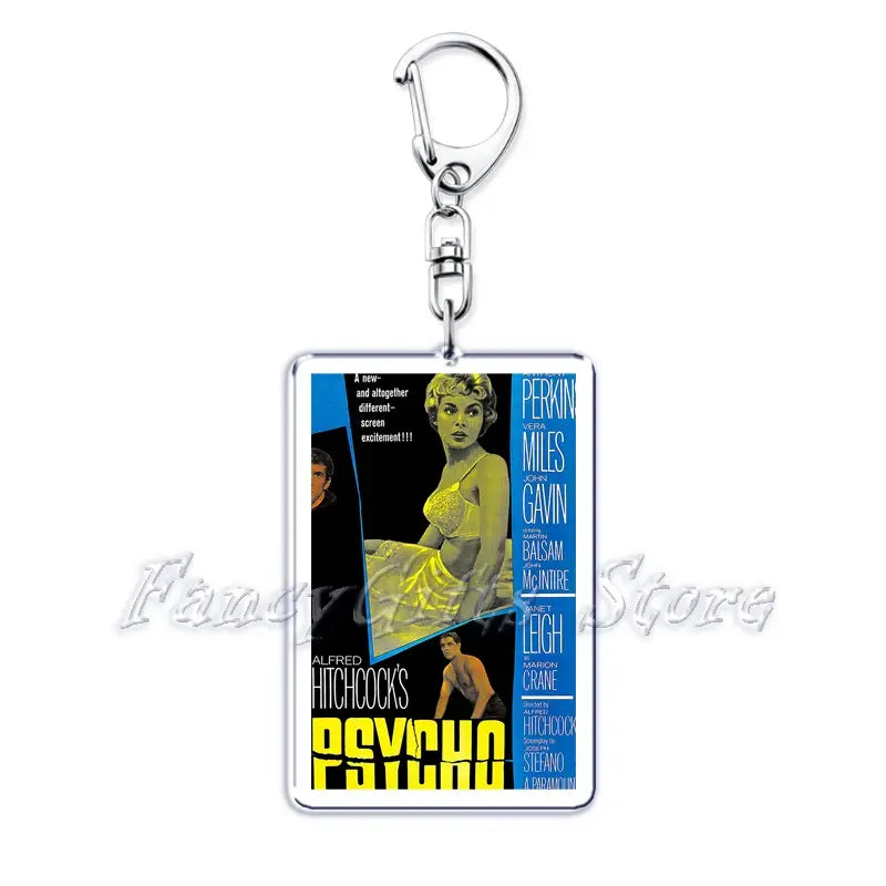 Silver rectangular acrylic keychain featuring a vintage alfred hitchcock psycho movie poster with bold yellow and blue text and actress janet leigh in a light-colored dress from the movie poster acrylic keychain set.