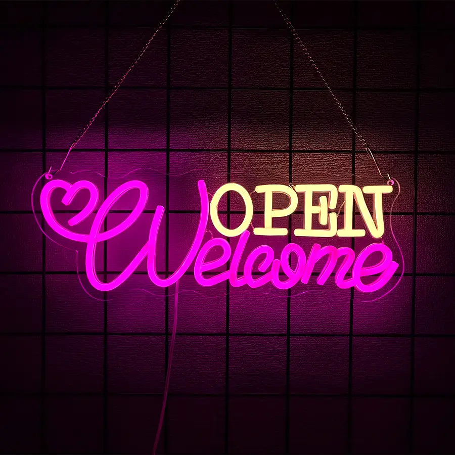 Enseigne au néon à LED vibrante rose et jaune, avec une touche décorative en forme de cœur portant le texte « Bienvenue, ouvert », décoration murale alimentée par USB, suspendue contre un mur sombre carrelé.