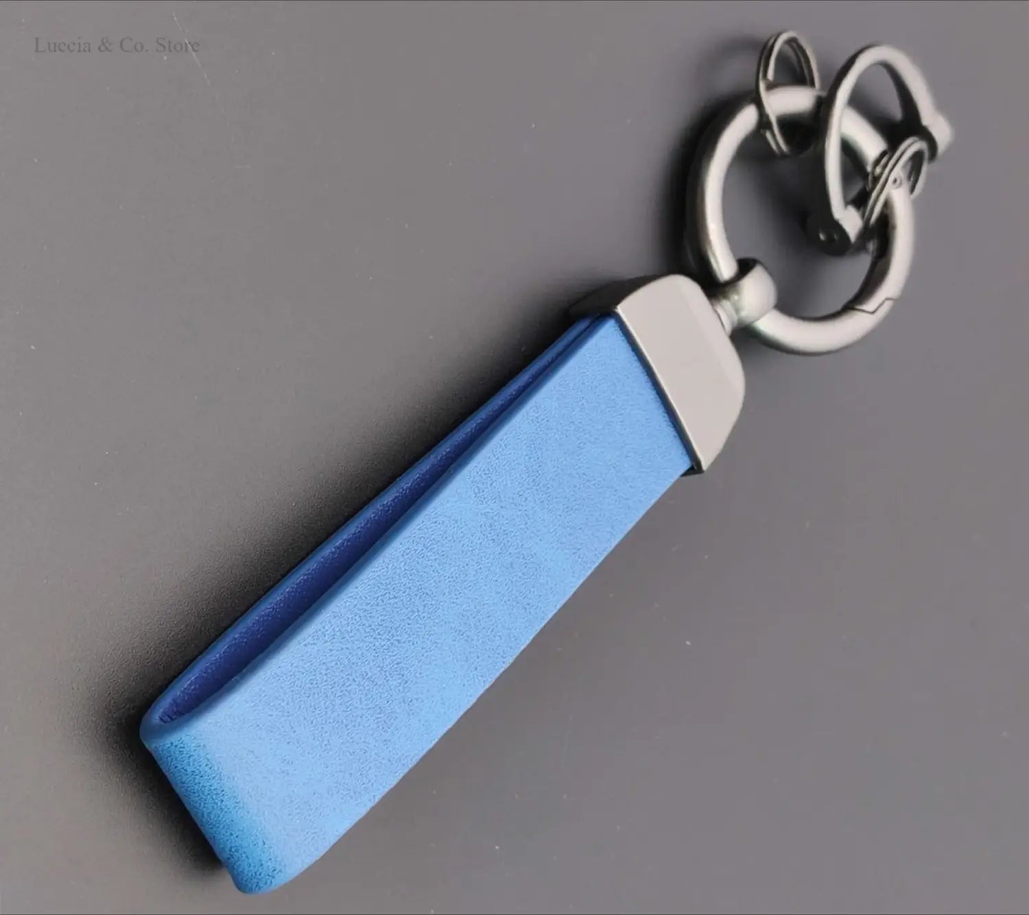 Blue leather custom logo car keychain with a silver-toned metal ring and connector for personalized use.