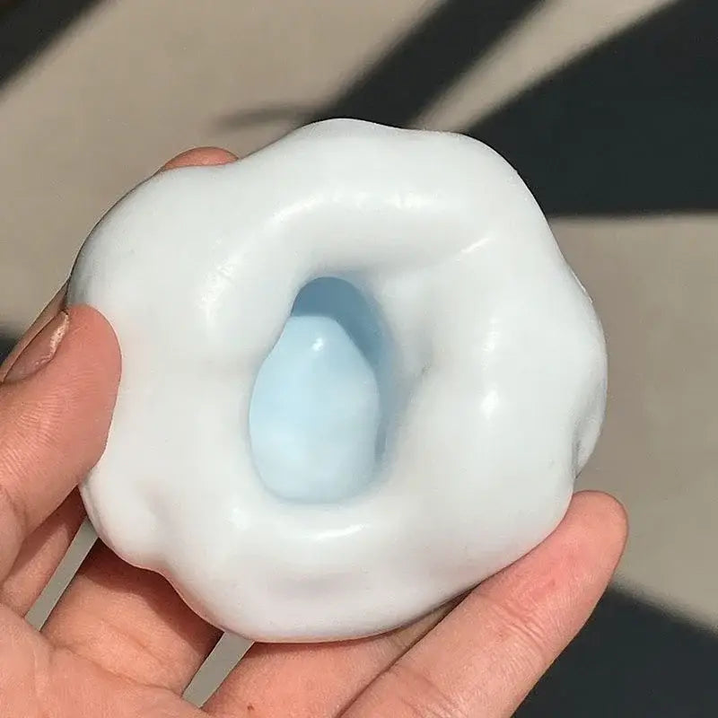 Ein glatter, weißer Keramik-Stressball-Fidget mit einer wolkenähnlichen Form und einem zentralen, hellblauen Hohlraum, entworfen für die knisternd-sensorische ASMR-Anwendung.