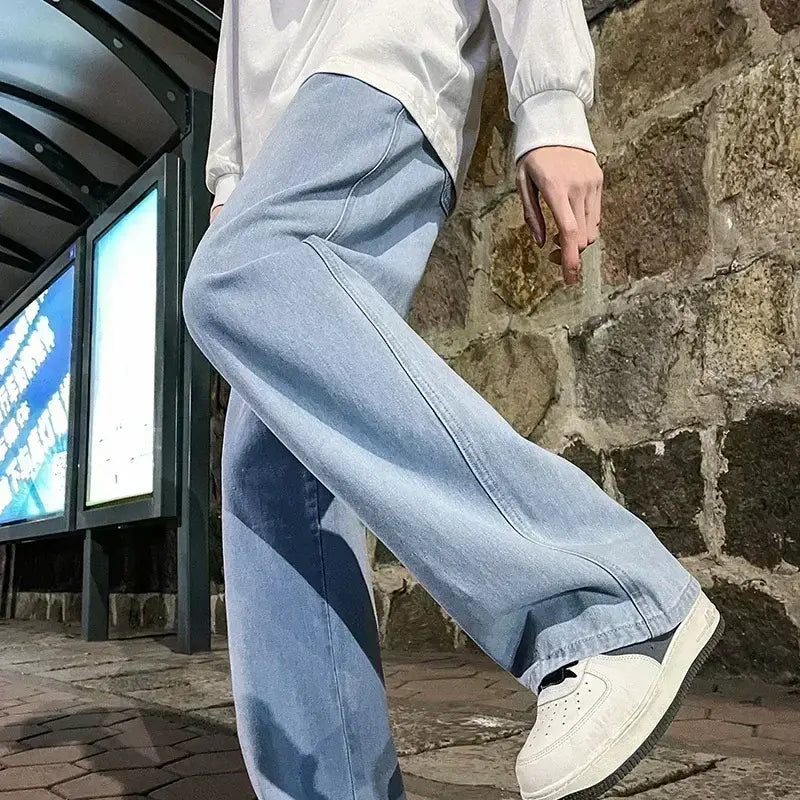 Jeans à jambes larges en denim à lavage clair pour hommes, avec une coupe ample et décontractée, adaptée à la mode streetwear coréenne.