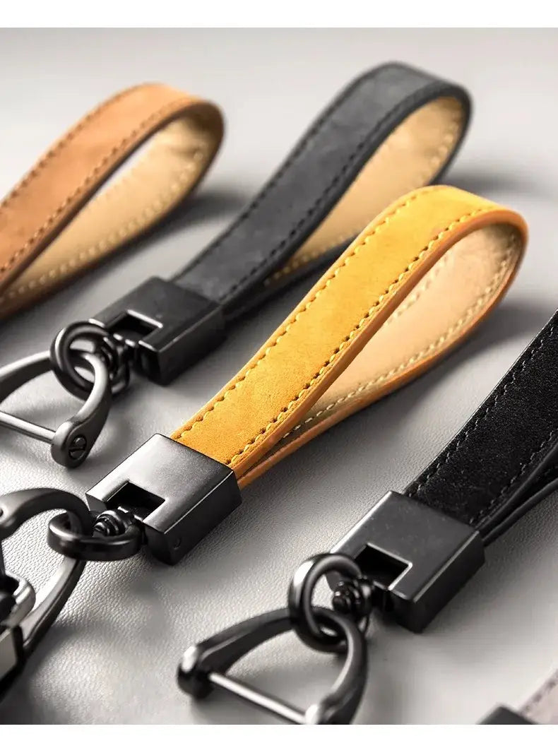 Genuine leather car keychains in tan and black with matte-finished metal d-ring clasps.