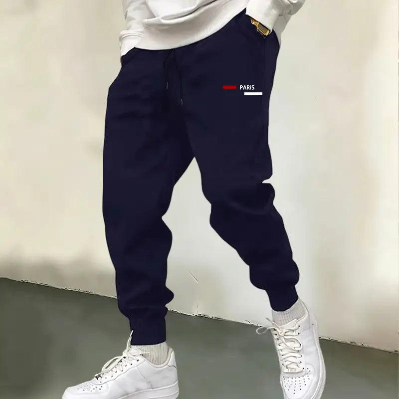 Dunkelblaue Jogger-Sweatpants für Herren mit Paris-Logo: mit weißem und rotem Paris-Logo auf dem Oberschenkel, ausgelegt für den Freizeitgebrauch.
