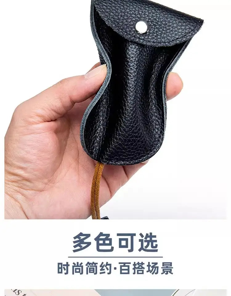 Schwarzes, strukturiertes Leder-Schlüsseletui mit Taschenhalterfunktion, mit silberfarbenem Druckknopf und beiger Kordel.