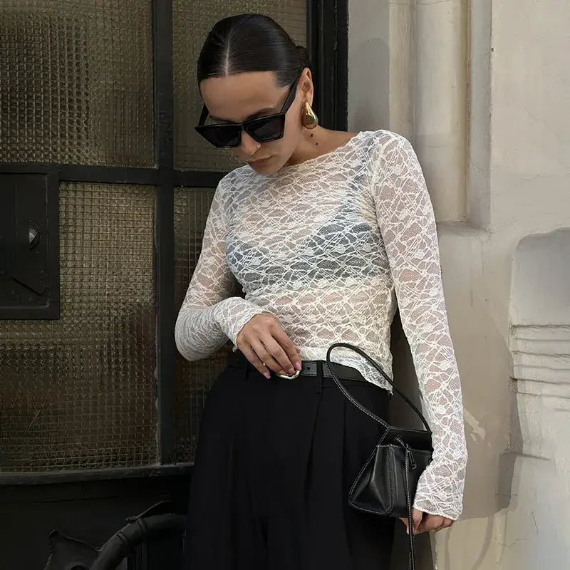 Women aesthetic clothes featuring a delicate white lace long-sleeved crop top with a sheer intricate pattern designed for a stylish and elegant look.