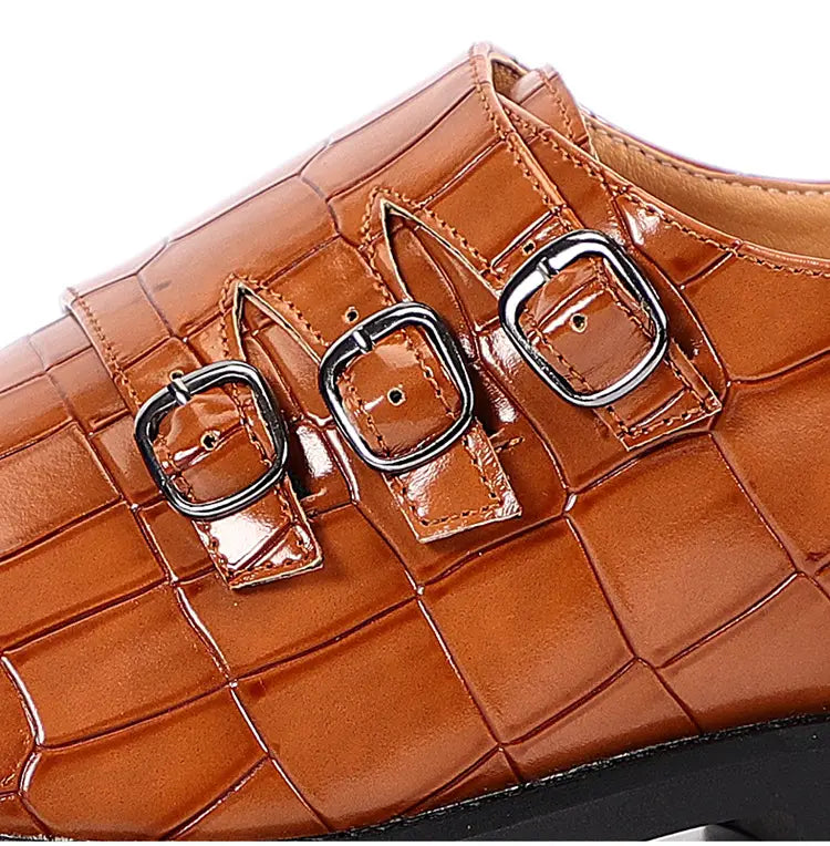Herren-Mönchsriemen-Kleidschuh aus Krokodil-narbigem Leder in Braun mit Krokodilmuster und drei schwarzen Metall-Schnallen.
