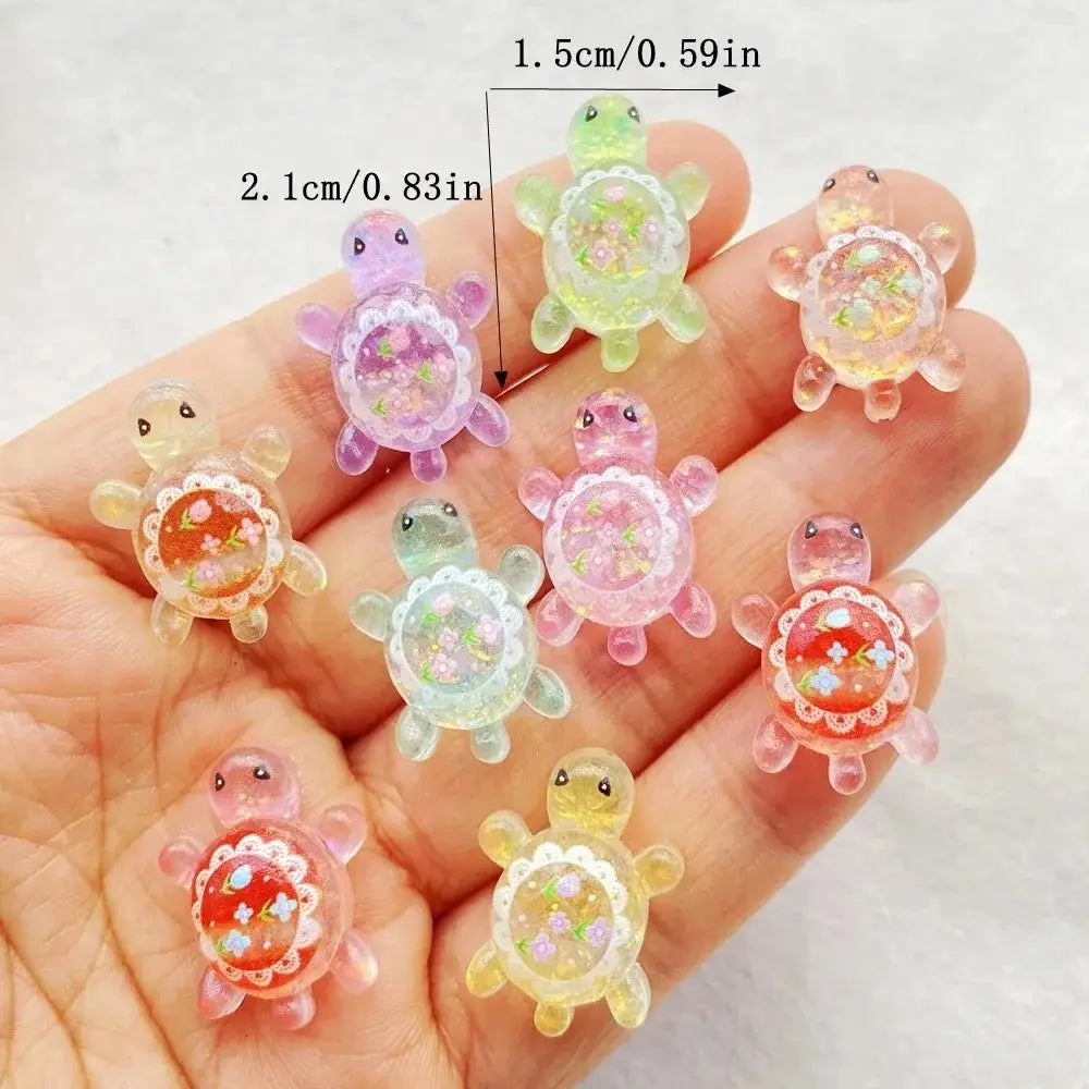 a collection of colorful translucent resin turtle flatback charms with floral designs inside their shells in a 10 pack set