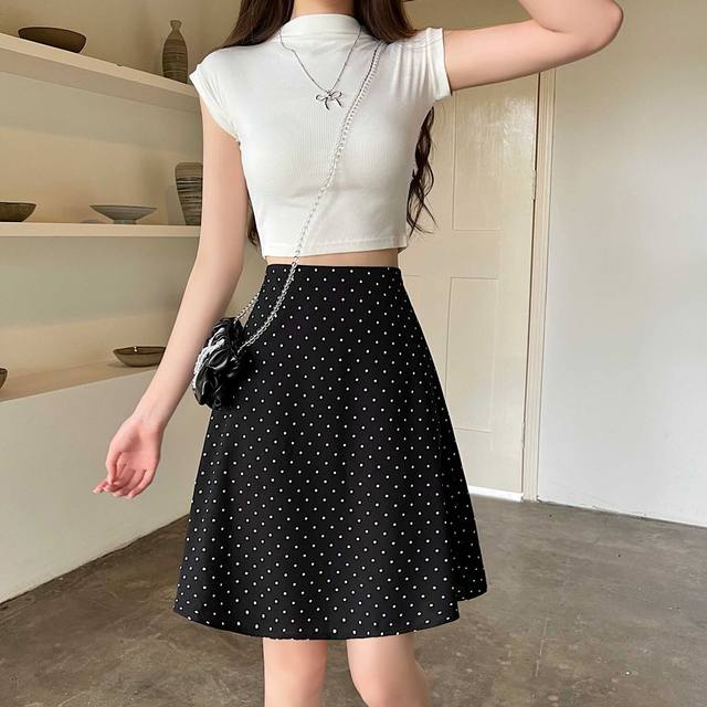 Falda midi línea A negra con lunares blancos y pretina alta adecuada para uso casual o formal