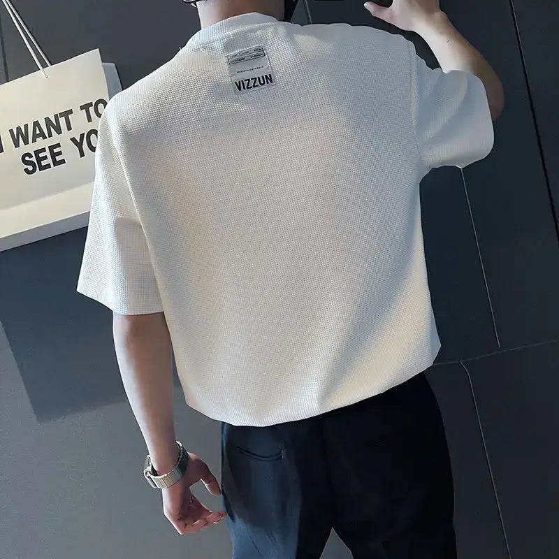 T-shirt pour homme à col ras du cou en maille côtelée blanche, tissu texturé, motif tissé discret et étiquette de marque au niveau de l’encolure.