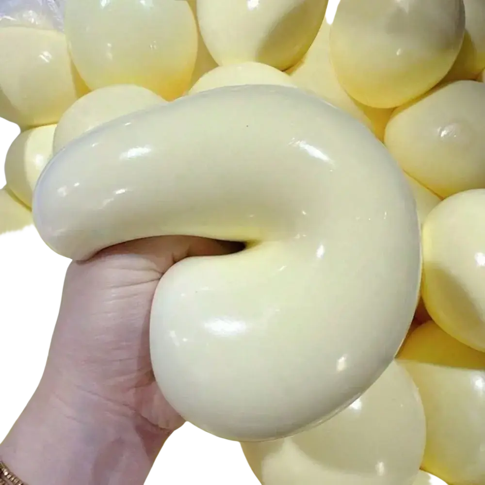 Cream-colored glossy silicone squishy ball with smooth flexible texture and curved shape for stress relief