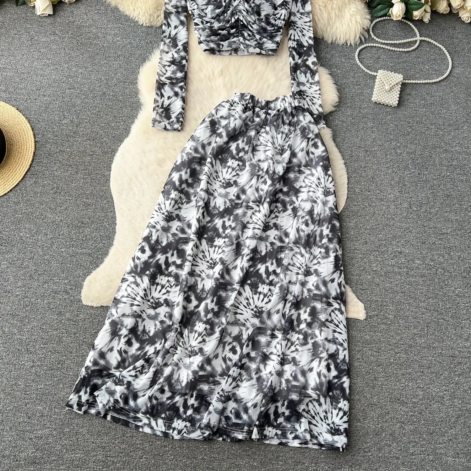 Black and white tie-dye two piece mesh skirt set with ruched long-sleeved top and elastic closure featuring a marble print design.