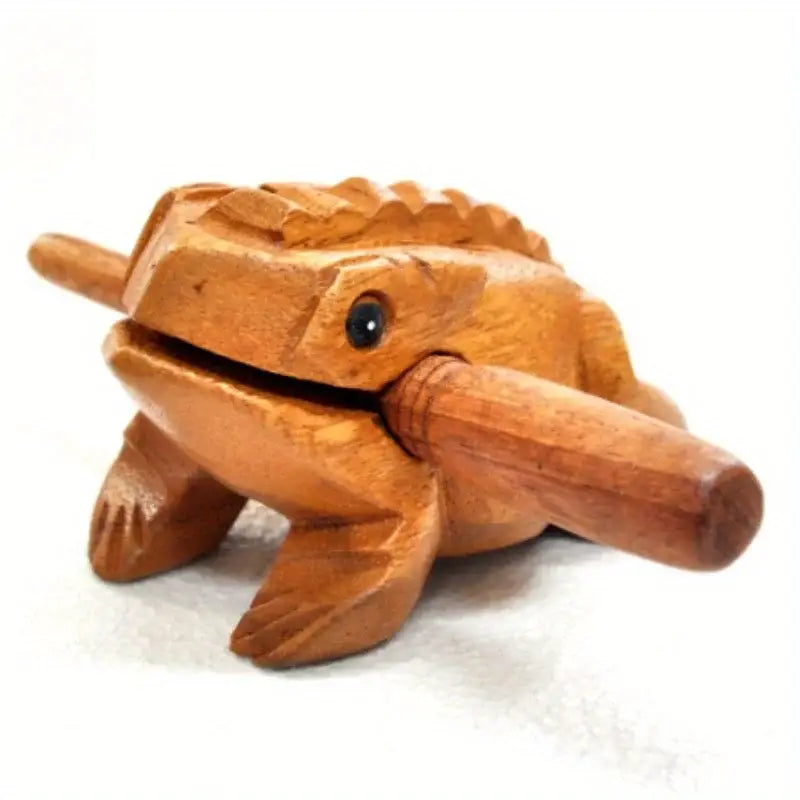 Hand carved wooden frog instrument and home decor featuring a smooth warm amber finish and detailed sculpted frog body as a rain wood nutcracker.