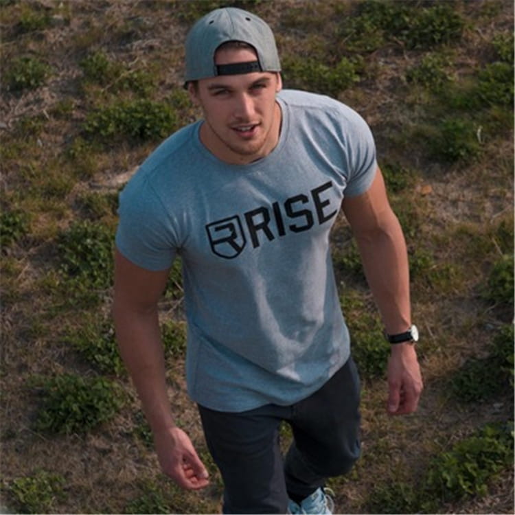 Herren-Workout-T-Shirt mit Gold-Rise-Logo in hellem Blau mit Kurzarm-Design; mit schwarzem Rise-Logo und Wappenemblem für den Einsatz als Activewear.