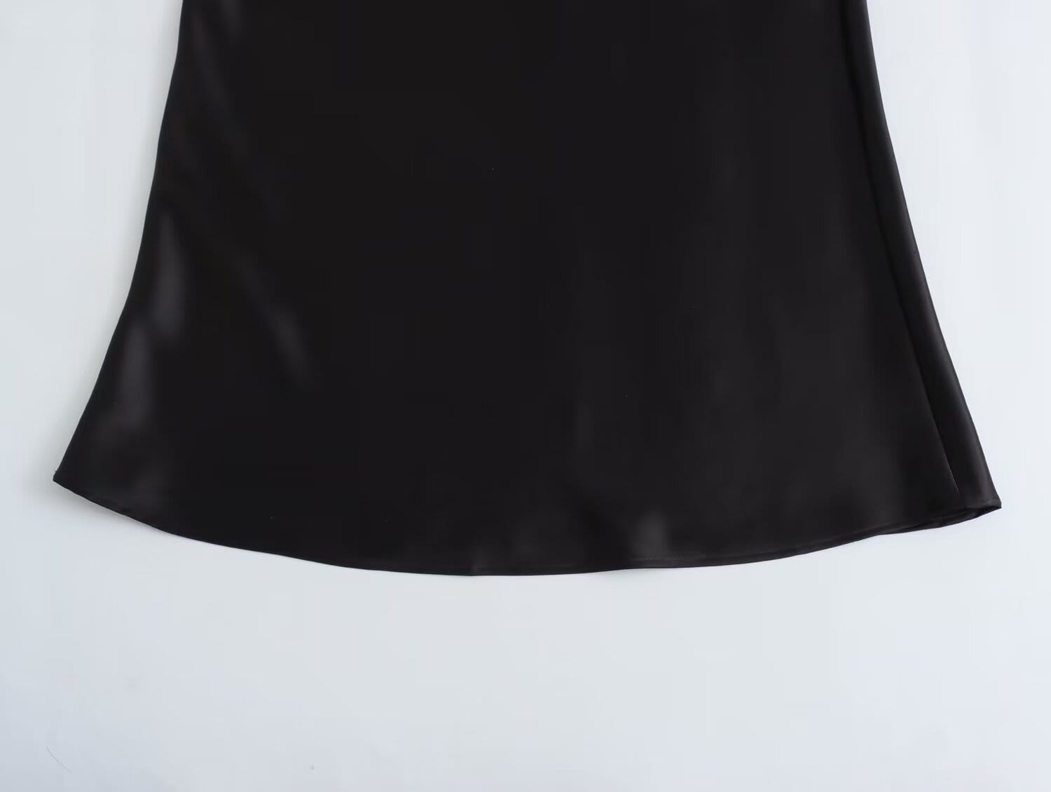 Jupe midi en satin noir à la silhouette fluide, taille haute, et design long élégant