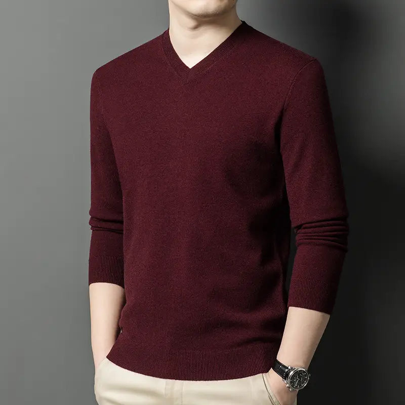 Ein bordeauxroter Herren-V-Ausschnitt-Strickpullover mit glatter, gestrickter Struktur und gerippten Bündchen.