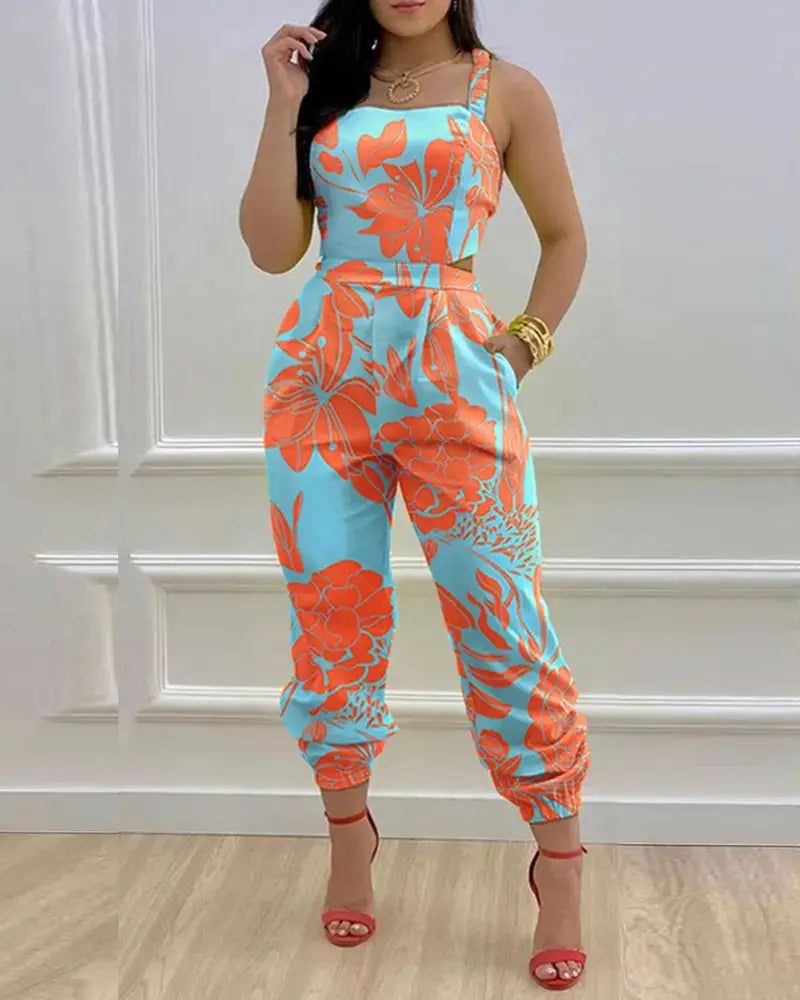 A vibrant turquoise and coral floral print women summer printed cutout jumpsuit featuring a square neckline, adjustable shoulder straps, and cuffed hems.