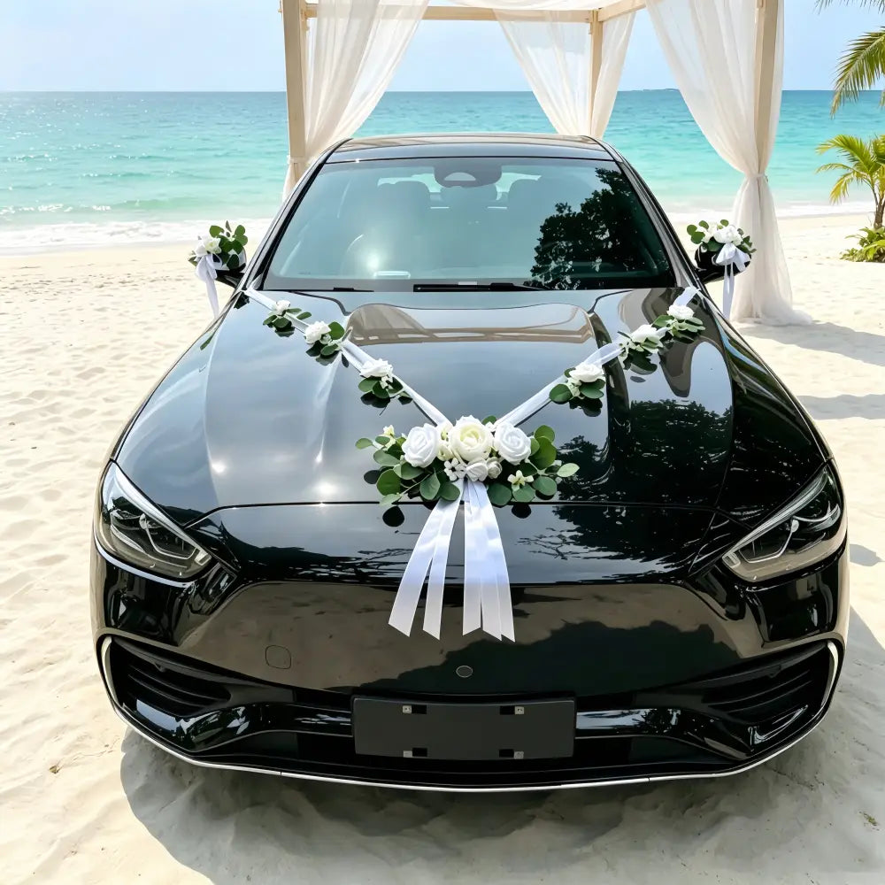 berline noire brillante décorée de roses artificielles blanches et d’arrangements floraux d’eucalyptus, ainsi que de rubans pour la décoration du kit de décoration de voiture de mariage