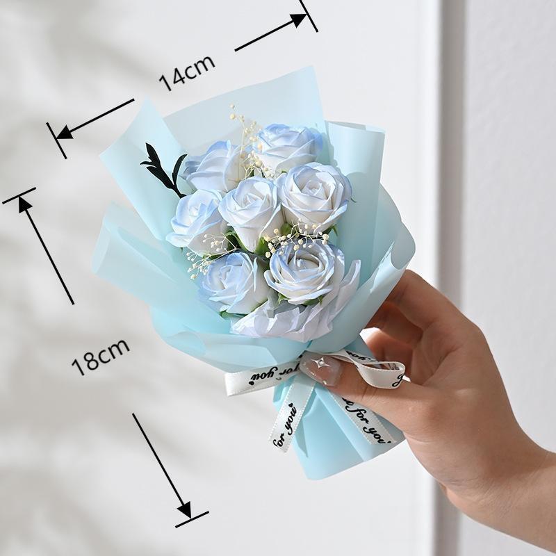 A delicate artificial rose flower bouquet featuring white roses wrapped in light blue tissue paper and tied with a ribbon reading for you, ideal for gifts.