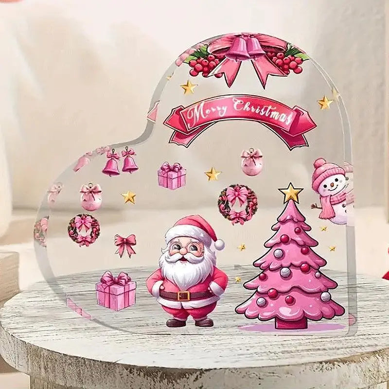 Soporte para adorno de escritorio en forma de corazón navideño de acrílico, que presenta un adorno de acrílico transparente color rosa con Santa, un árbol y decoraciones festivas.