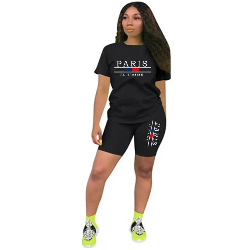 Ensemble deux pièces pour femmes en noir style paris : « Paris je t’aime » sur un haut à enfiler avec fermeture et un short, comprenant un t-shirt à manches courtes et des shorts cyclistes assortis, avec texte blanc et des rayures rouges et bleues.